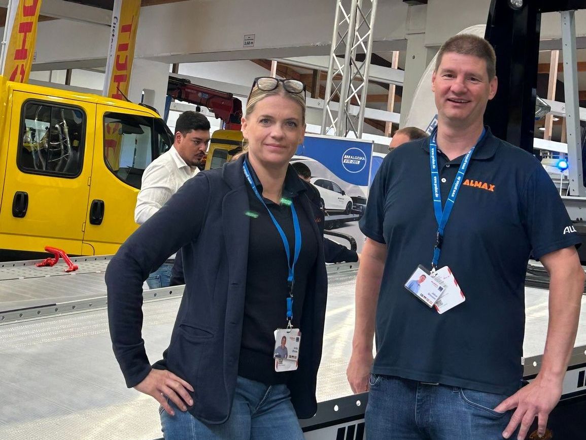 Anita och Johan framför ett biltransportsläp på en mässa