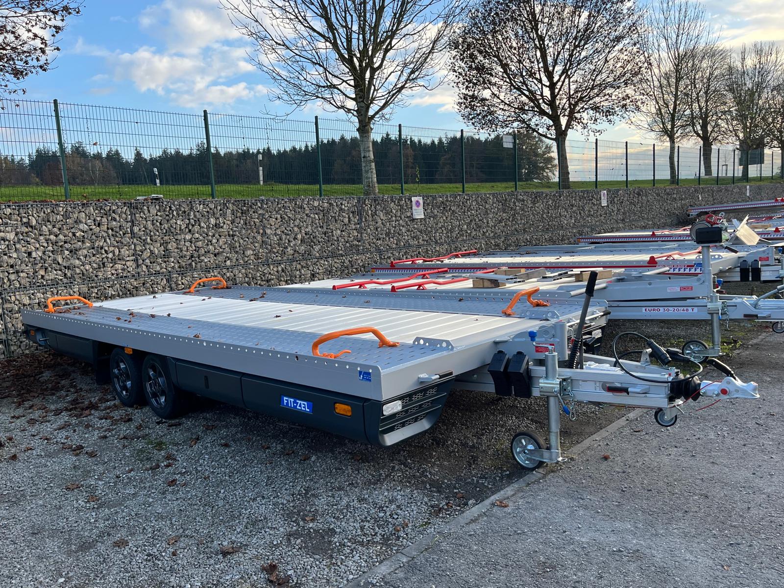 Flera parkerade biltrailers med Maxino från Fit-Zel i förgrunden