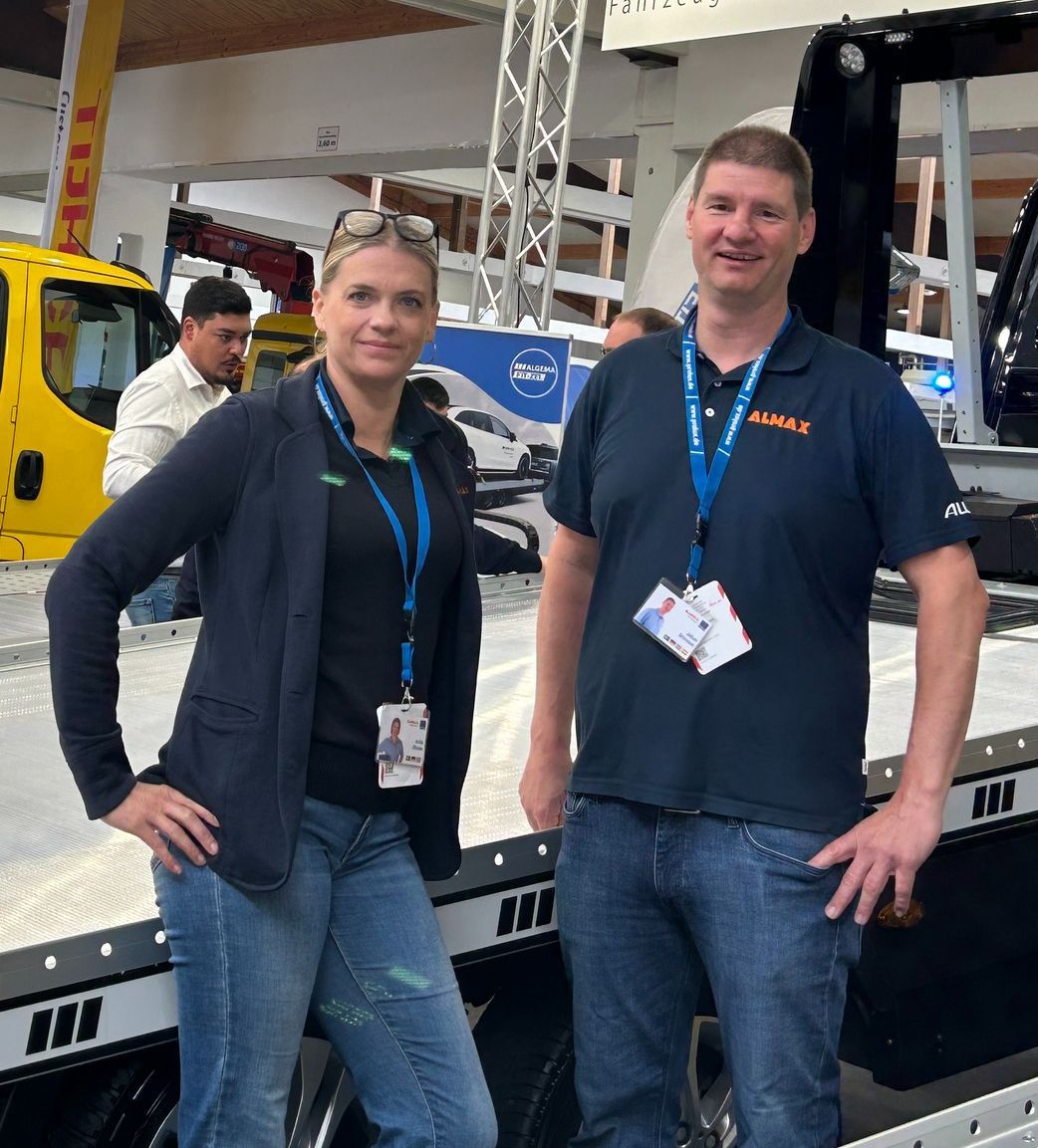 Anita och Johan framför ett biltransportsläp på en mässa