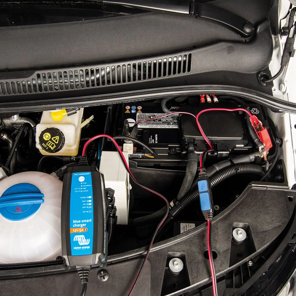 Öppen motorhuv, med en batteriladdare inkopplad